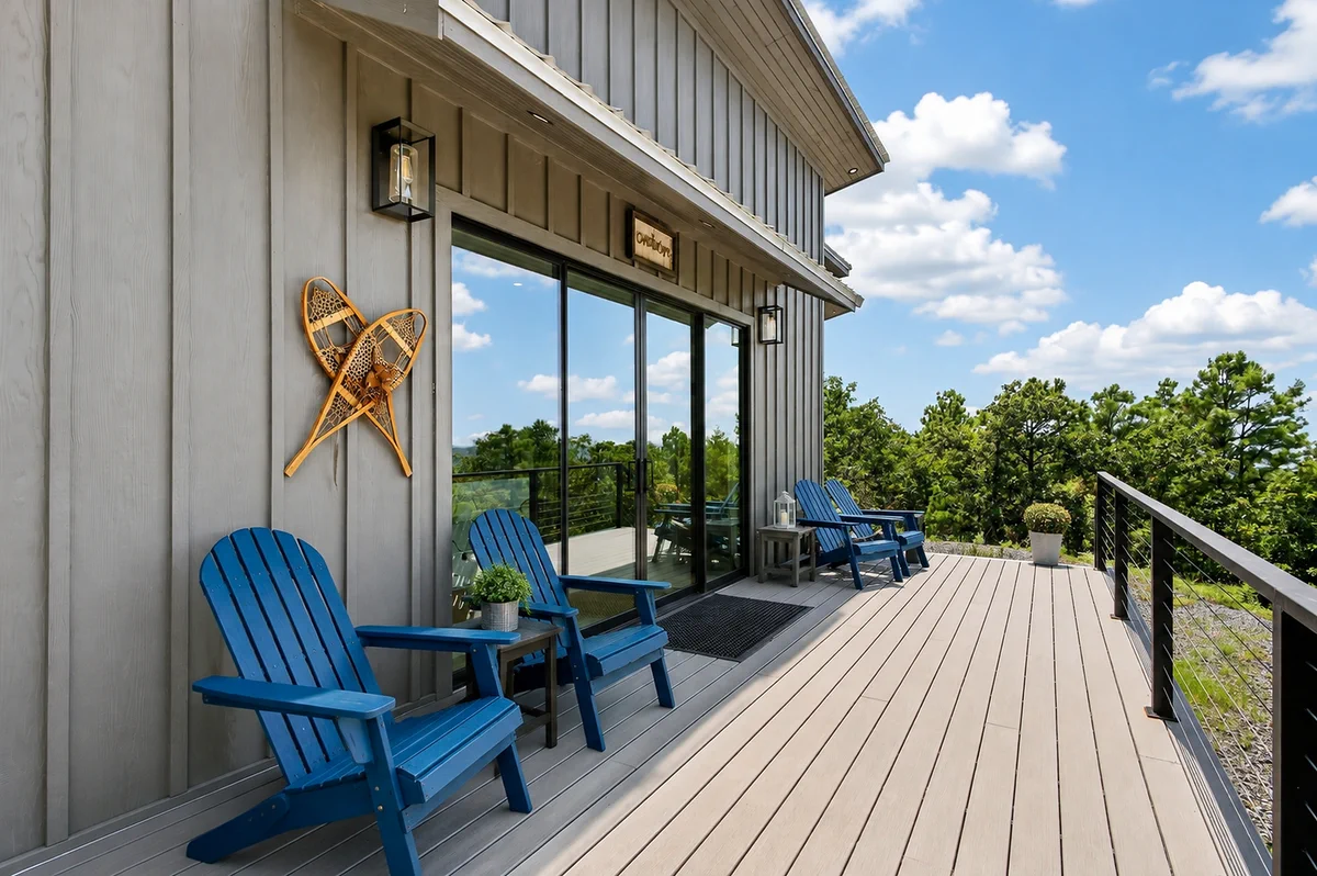 Blue chairs on the deck overlooking the wooded mountain terrain