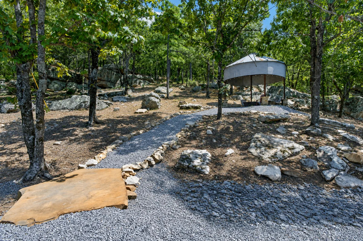 Rock-lined trail winding between mature trees on the property